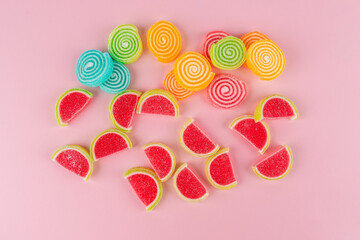 Fototapeta premium Colorful sugar-coated jelly candies against a pink background. 