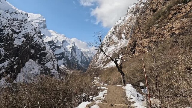 First-person view hiking the snow-edged path down from the Sanctuary, Annapurna, Nepal