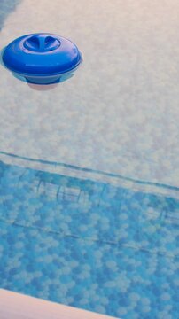 A blue chlorine dispenser floating in a swimming pool