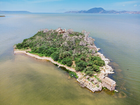 island showing ancient monastery ruins and arid trees surrounded by Bafa Lake with Latmos Mountains in background