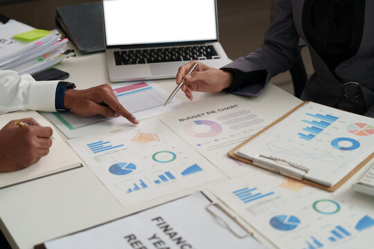 Cropped hands of business colleagues analyzing financial charts on desk for budget planning