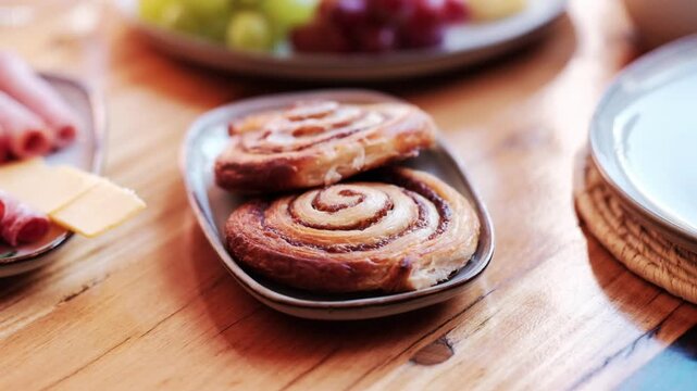 Two pastry swirls on a plate at a breakfast spread