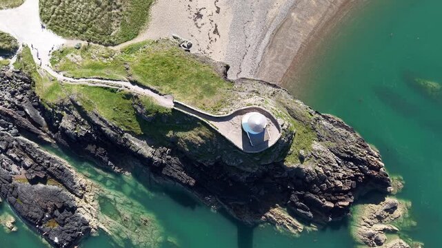 Top down circle from high drone over llanddwynn lighthouse in Wales