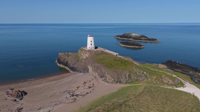Medium height drone flight circling right to left looking towards llanddwynn lighthouse.