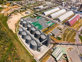 View of industrial area with storage silos and various buildings in the background during daylight © DSMT