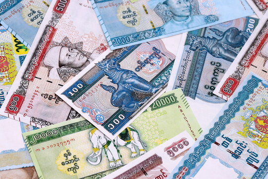 Myanmar kyat money bills pile on table. Myanmar banknotes of MMK currency close up.
