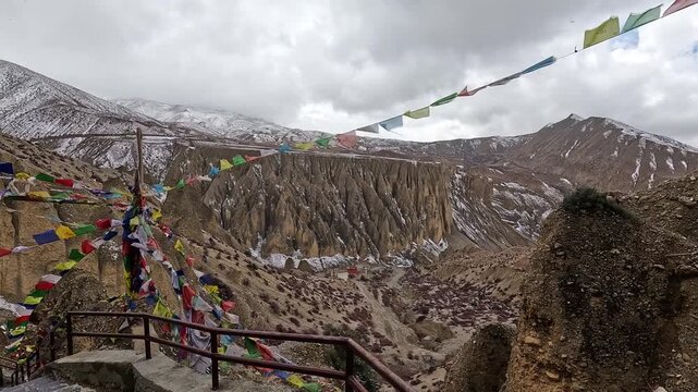 Follow steep stairs downf from Monastery. Prayer flags strung across eroded canyon cliffs at Shree Luri Gompa, Upper Mustang, Nepal