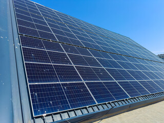 Obraz premium Solar panels installed on a roof at a location with clear blue skies during the daytime showing renewable energy use for power generation