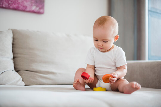 Baby girl playing on couch at home