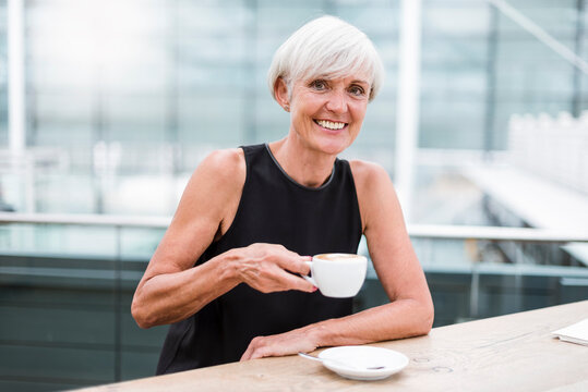 Portrait of smiling senior woman drinking a coffee