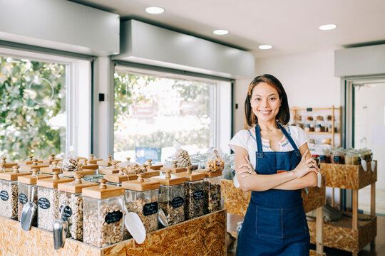 Confident shopkeeper smiling in an eco-friendly bulk store