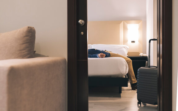 Businessman relaxing on bed at hotel room