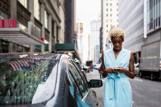 USA, New York, young blonde african-american woman using smartphone