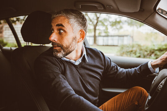 Businessman driving car turning round