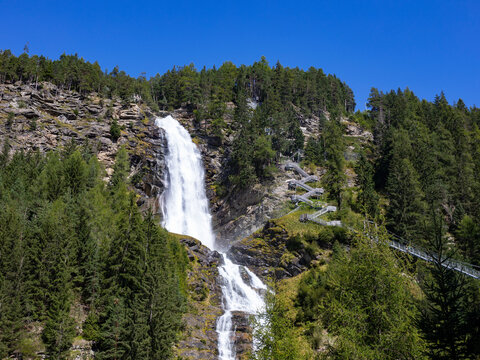 Austria, Tyrol, Umhausen, View of Stuiben Falls in summer with suspension bridge in background