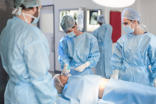 Surgical team anesthetizing patient
