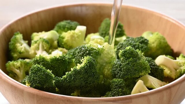 Fresh broccoli in a wooden bowl with clean water for soak and cleaning prepare for cook