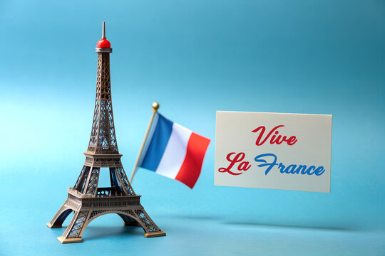 a miniature of the Eiffel Tower, a french flag and the text fete nationale 14 juillet, the national day of France written in French, against a pale blue background