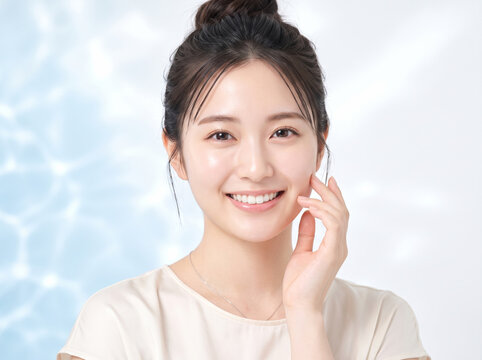 水のきらめき背景で頬へ指を優しく添える女性