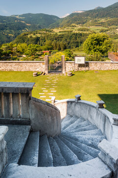 Stone spiral staircase overlooks a historic garden and mountain landscape, Monte Baldo Natural Park, Palazzo Baisi e Giradino dei Semplici, Brentonico, Trentino, Veneto, Italy.