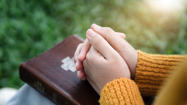 Christian Prayer with Folded Hands on Holy Bible in Nature, Faith and Spiritual Devotion