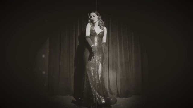 black and white color film retro lady sexy happy woman fashion model posing dancing, long dress gloves. girl beauty face burlesque old style glamour actress stands on stage room. hair 20s new year