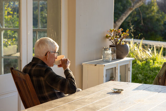 elderly man sipping tea outdoors at sunset