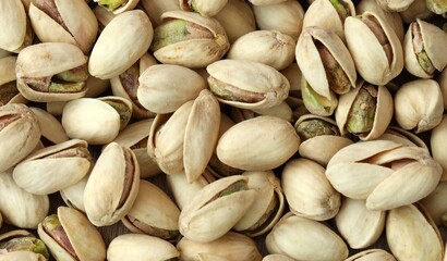 Fototapeta premium A photo of a pile of pistachios, with the majority still in their shells. Big amount of pistachios