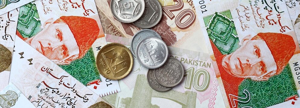 Pakistani rupee money banknotes and coins on table. Pakistan cash bills of PKR currency