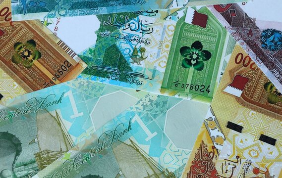 Qatari riyal money bills in pile. Big amount of Qatar QAR currency cash close up. Concept of casino