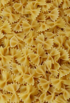 Uncooked Farfalle Pasta, Bow-Tie Macaroni Creating a Lively and Textured Background
