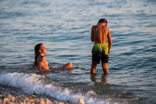 Children playing in ocean waves during summer vacation