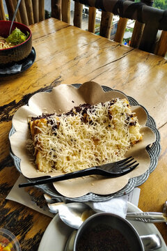 Chocolate cheese toast served with hot black coffee on a rustic wooden table. Cozy caf&eacute; breakfast, snack or dessert with appetizing presentation.