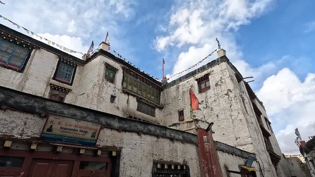Low angle souvenir shop facade prayer flags and Royal Palace exterior, Lo Manthang Upper Mustang Nepal