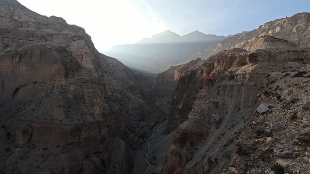 Deep narrow gorge at dusk, small river at base of vertical sandstone walls, Upper Mustang Nepal