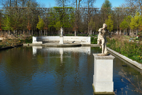 Statues by a scenic pond in the Tuileries Garden, Paris.
