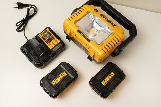 Kharkiv, Ukraine, July 12 2026: Illustrative editorial of DeWalt DCL077 LED Work Light with 20V Batteries and Charger Flat Lay on White Background.