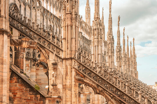 Long perspective of gothic marble spires and buttresses of Milan Cathedral.