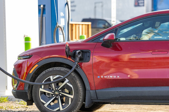Gaspesie, Canada, 30 May 2026 : Red Chevrolet Equinox electric vehicle charges at a public charging station.