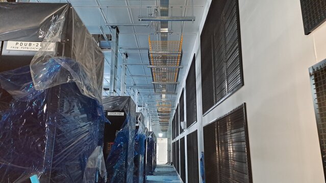 data center construction site with wrapped pdu units and hvac ventilation ducts