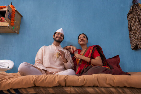 Maharashtrian couple having tea while sitting on cot at home