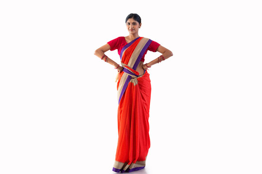 Portrait of a cheerful woman gesturing with wooden spatula and rolling pin in hands against white background