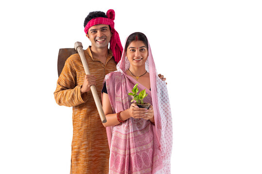 Portrait of happy couple standing with spade and  house plant against white background