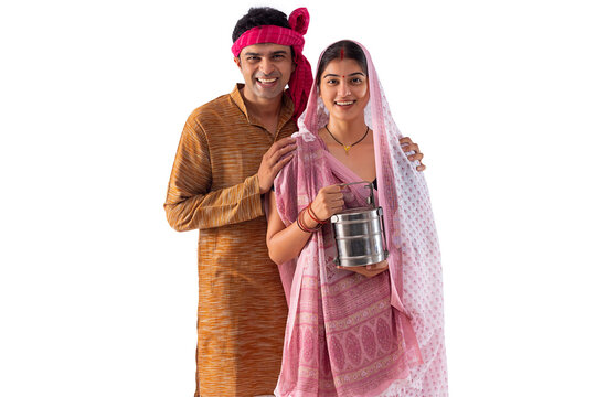 Portrait of happy couple standing with lunch box against white background