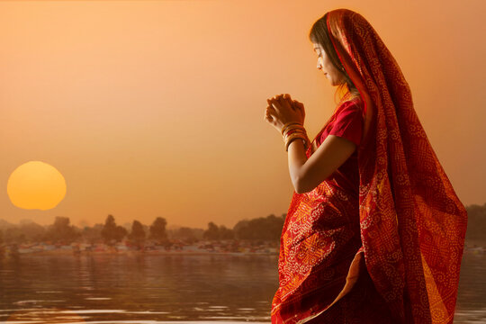  woman from Bihar offers prayers to the  sun  in the  early morning hours   during  Chhath Puja festival