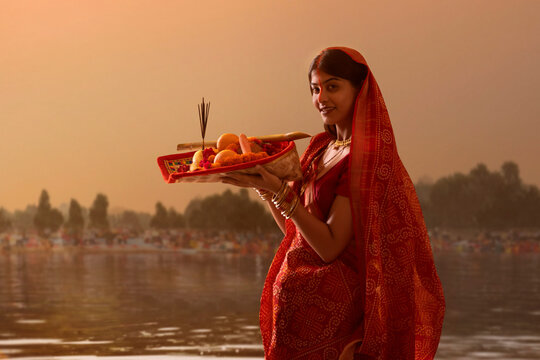 woman from Bihar offers prayers to the  sun  in the  early morning hours   during  Chhath Puja festival