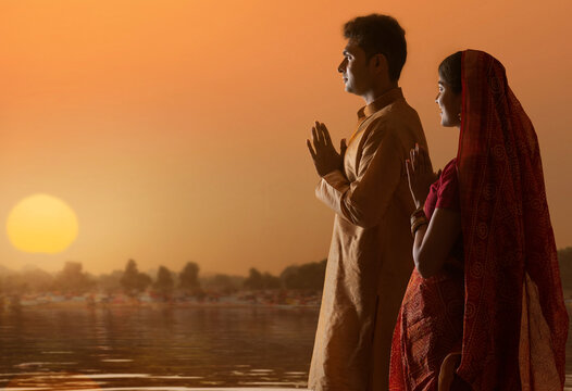 Couple from Bihar offers prayers to the  sun  in the  early morning hours   during  Chhath Puja festival