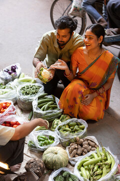 Couple buying vegetable from street market
