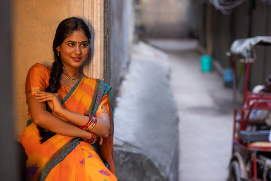 Portrait of young woman sitting at door step