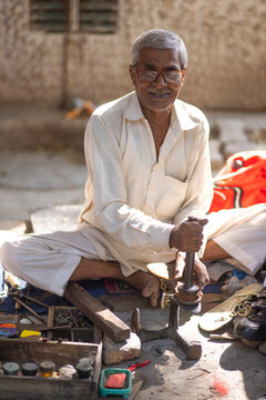A cobbler repairing shoes on the streets of Delhi